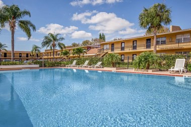 apartments overlooking sparkling pool and palm trees