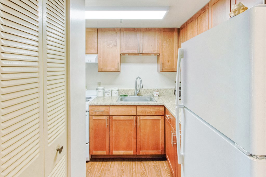 kitchen with white appliances, wood cabinets, and pantry doors