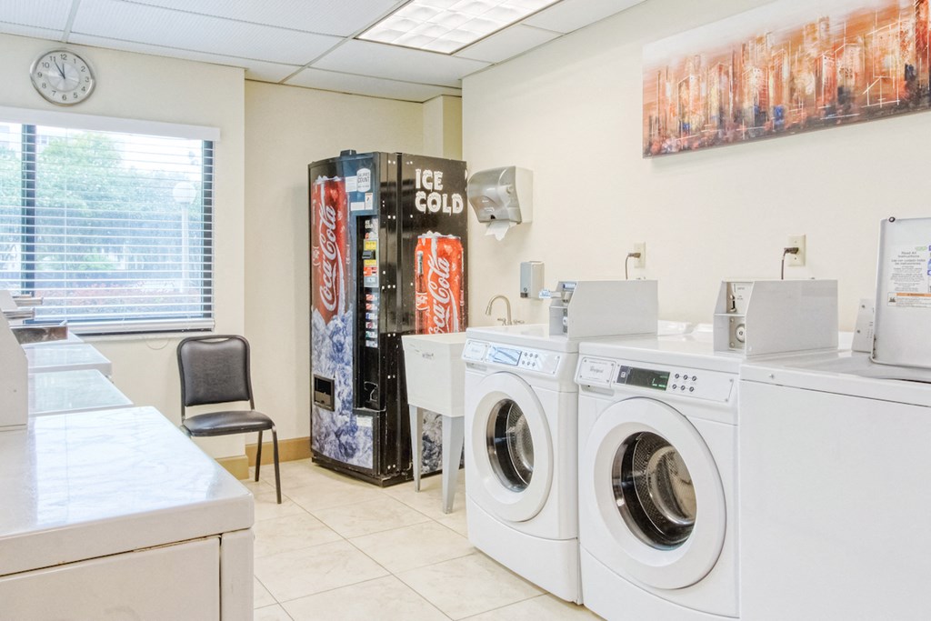washers and dryers in laundry center with drink machine and wash sink
