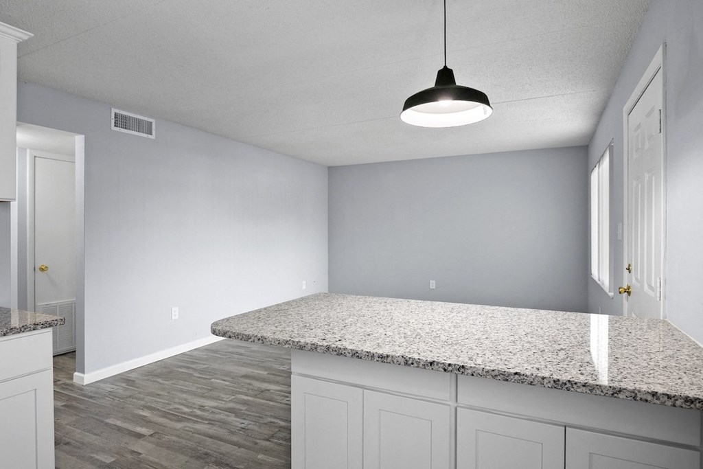 the kitchen and living room in a new home with white cabinets
