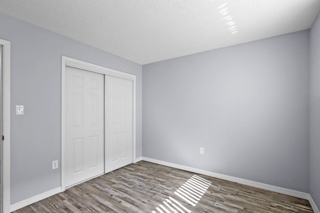 an empty room with a white door and grey walls