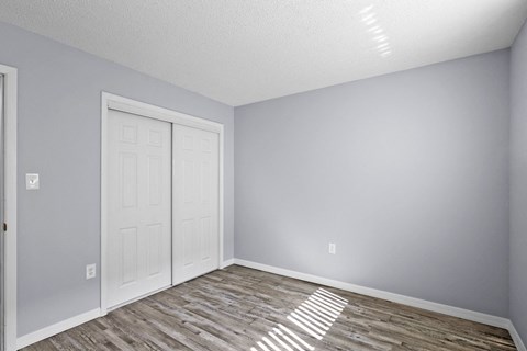 an empty room with a white door and grey walls