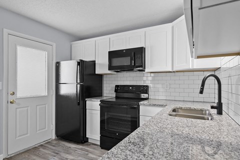 a kitchen with black appliances and white cabinets