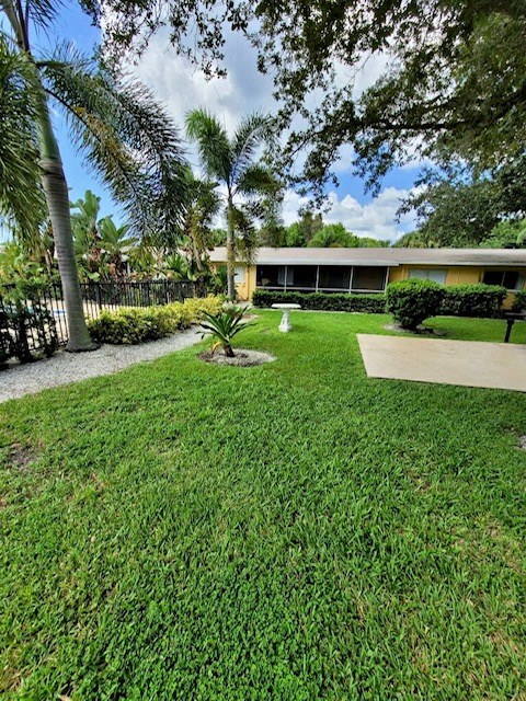 lush courtyard with green grass, patio, and birdbath