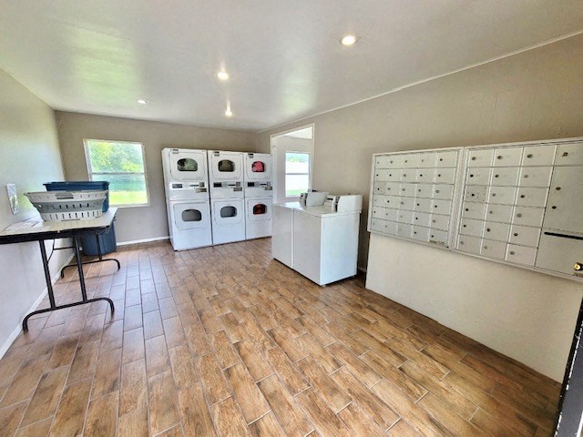 mailboxes and laundry center with washers, dryers, and folding table