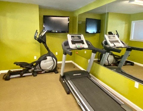 fitness center with cardio equipment and TV