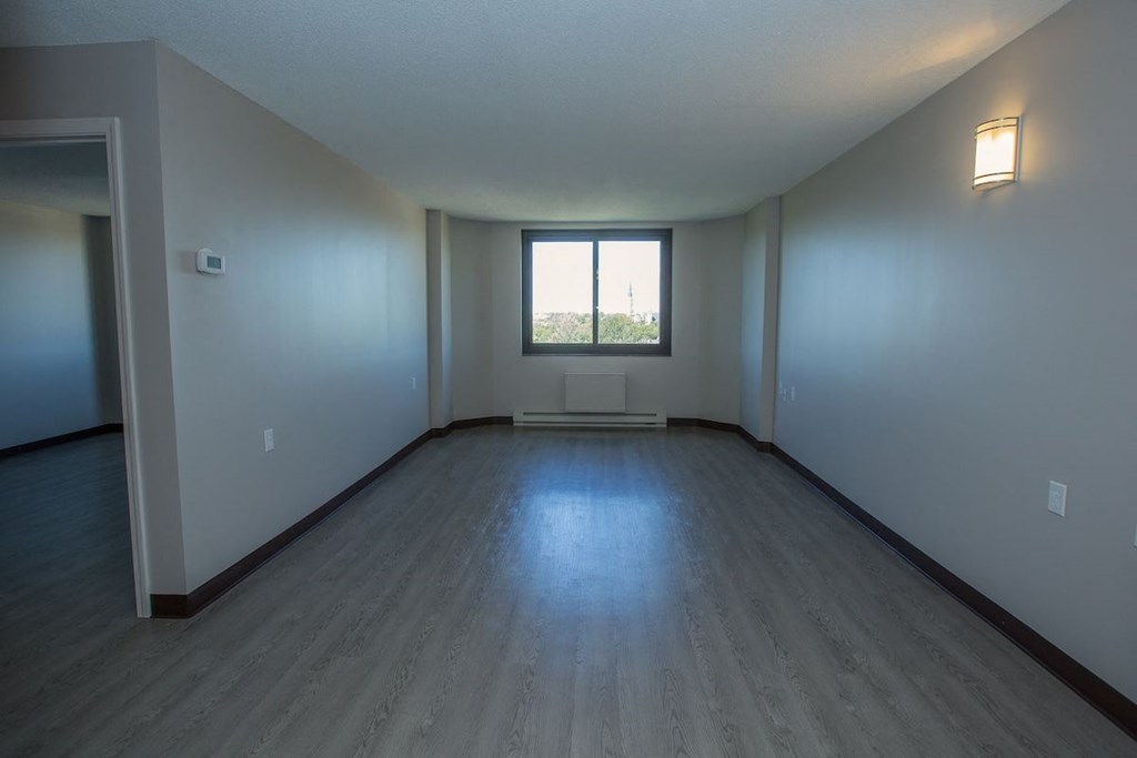 a large living room with a wall sconce and window at Piotr Stadnitski Gardens
