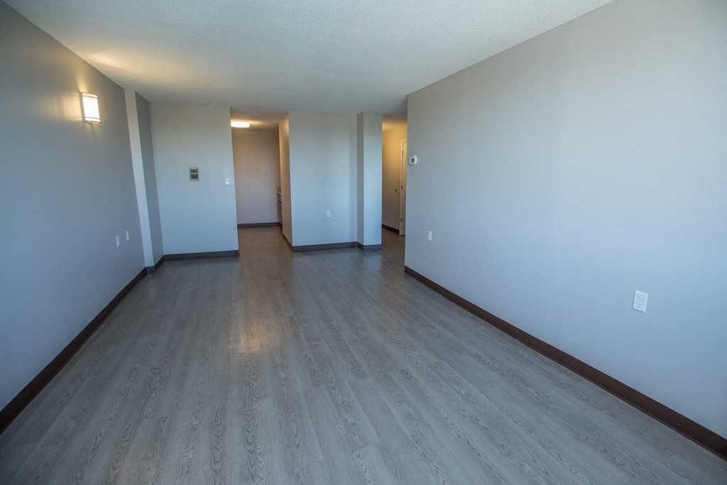 a spacious living room with wood-style flooring at Piotr Stadnitski Gardens in Buffalo, NY