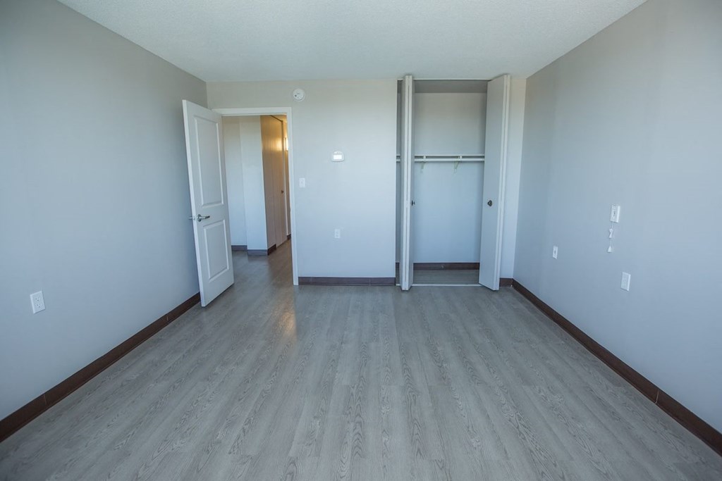 a bedroom with wood-style flooring and a closet with a bar at Piotr Stadnitski Gardens