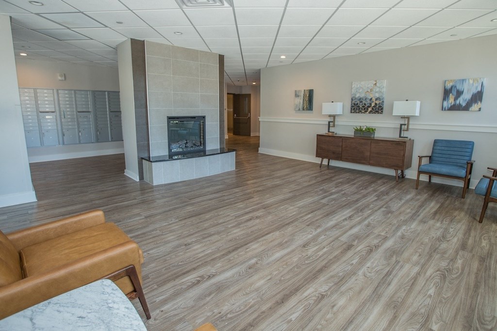 The ground floor lobby at Piotr Stadnitski Gardens with seating, a fireplace, and resident mailboxes