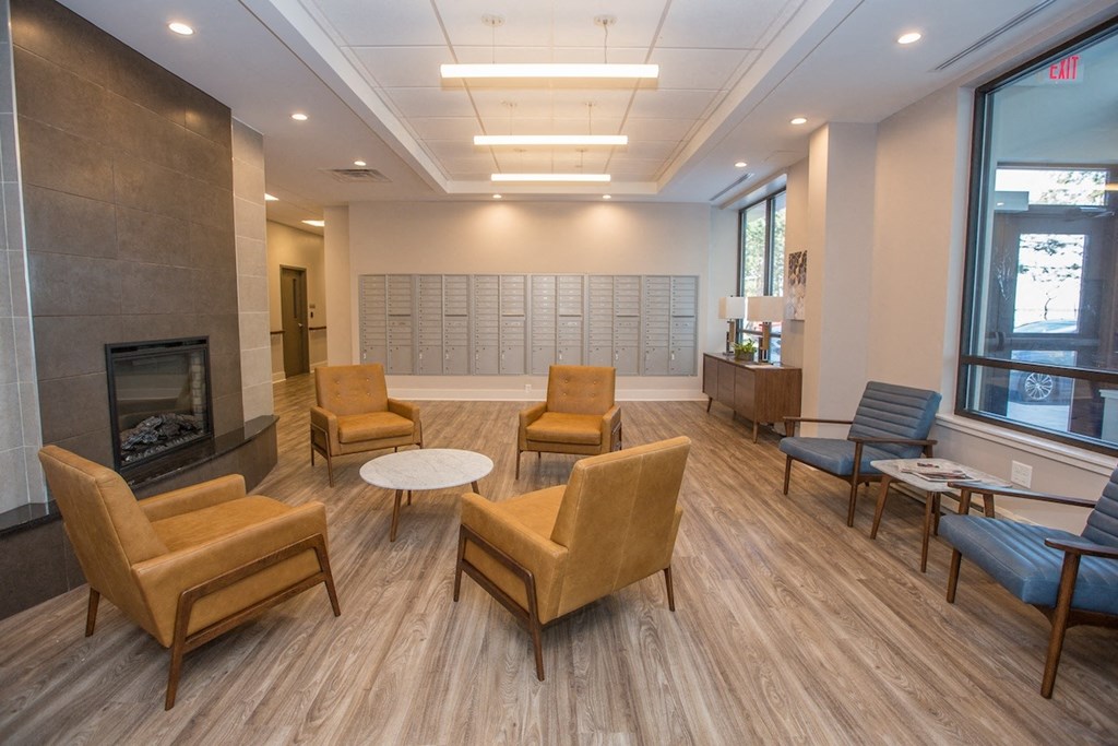 Riverview Manor Lobby with seating areas, a fireplace, large windows, and resident mailboxes