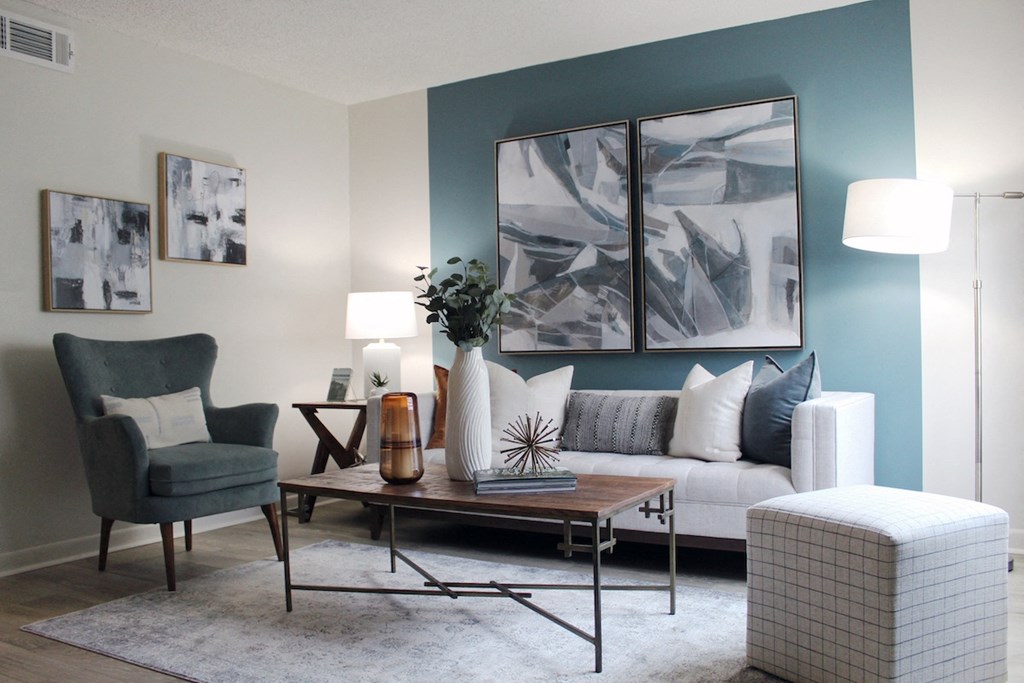 living room with hardwood-style flooring and teal accent wall and model furniture  at Huntsville Landing Apartments, Alabama, 35806
