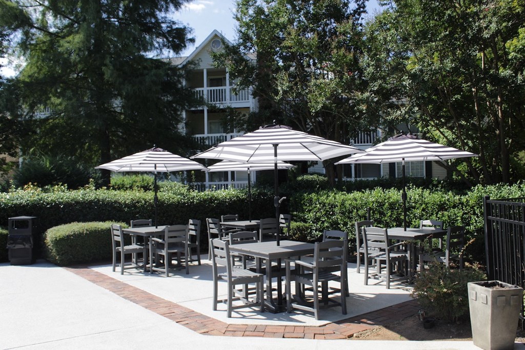 poolside patio with tables and umbrellas at Stillwater at Grandview Cove in Simpsonville, SC