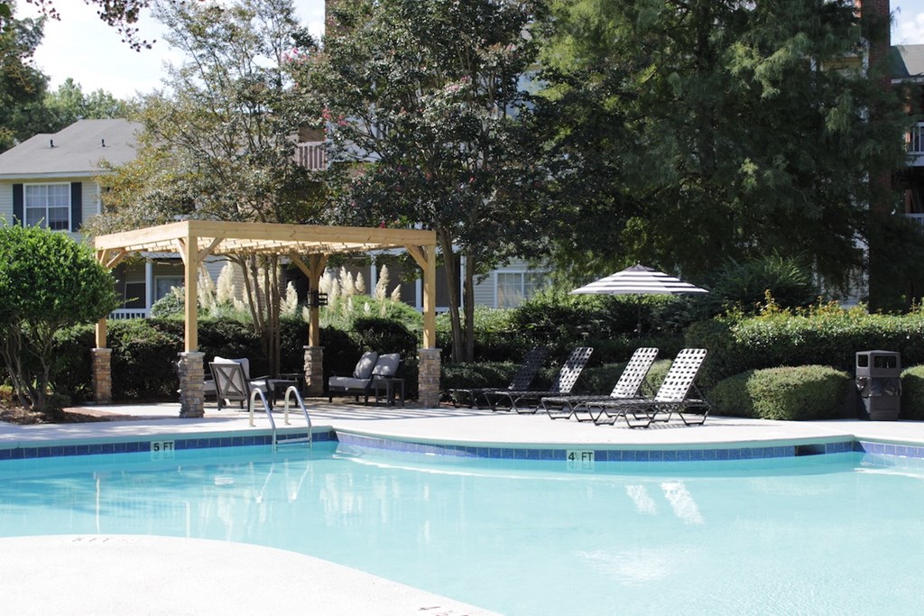 a swimming pool with chaise lounge chairs and a pergola at Stillwater at Grandview Cove