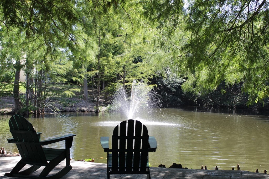 a fountain in a pond with two adirondack chairs at Stillwater at Grandview Cove