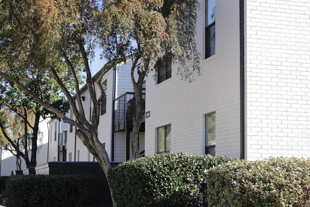white painted residential building with lush landscaping at Rock Creek Apartments in Cordova, TN