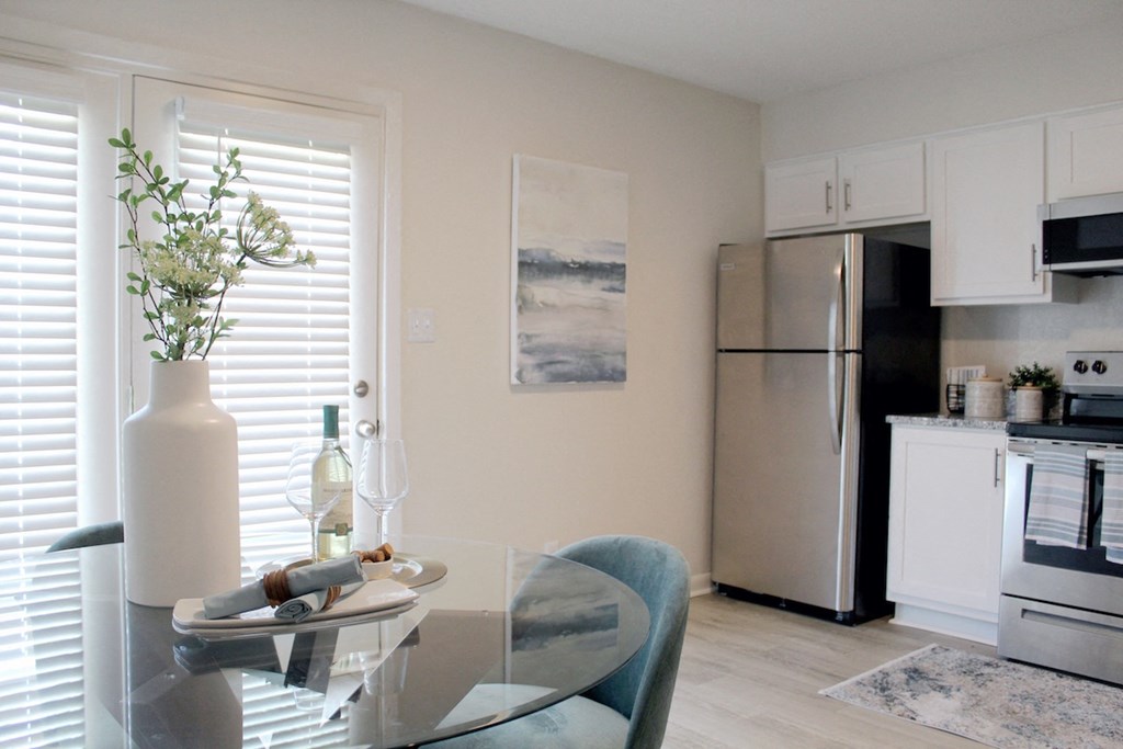 kitchen with stainless steel appliances and dining room with hardwood-inspired flooring  at Huntsville Landing Apartments, Huntsville, AL