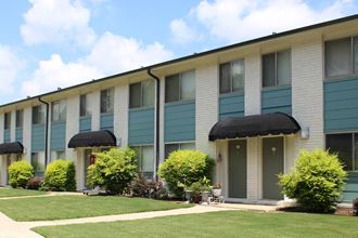 well-kept Sherwood Park Apartment homes exterior with fresh paint, door awnings, and neat landscaping  at Huntsville Landing Apartments, Alabama, 35806