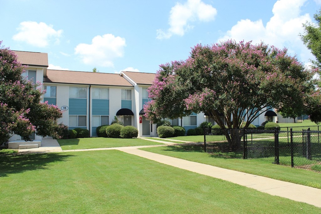 lush courtyard with sidewalk, fenced dog park, and lush landscaping at Sherwood Park Apartments  at Huntsville Landing Apartments, Huntsville