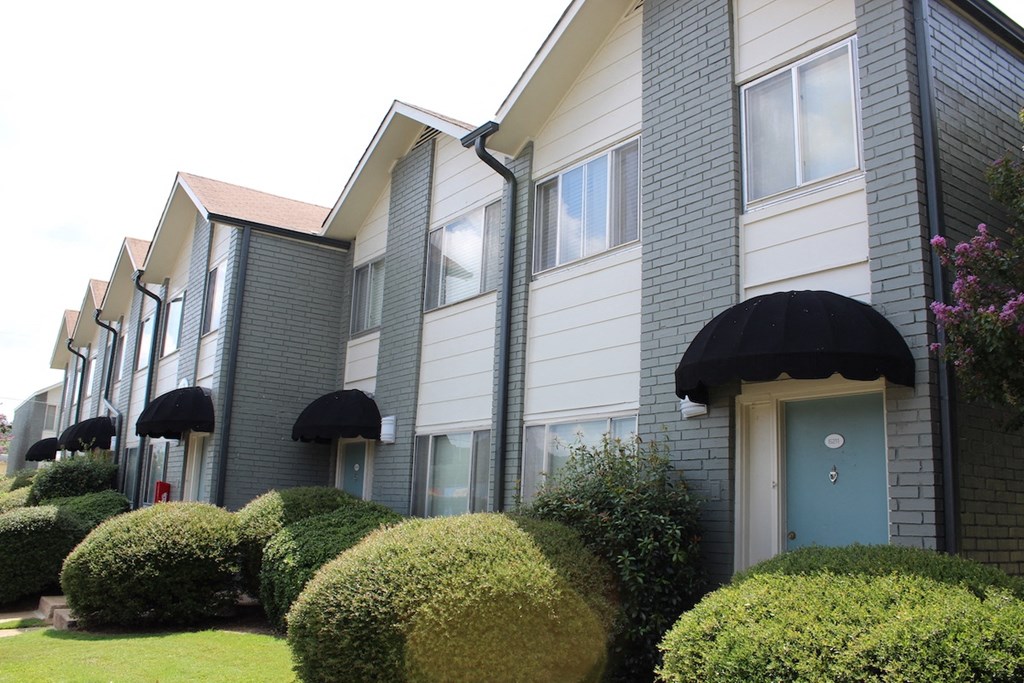 apartments painted white and grey with teal doors and black awnings and mature landscaping  at Huntsville Landing Apartments, Alabama, 35806