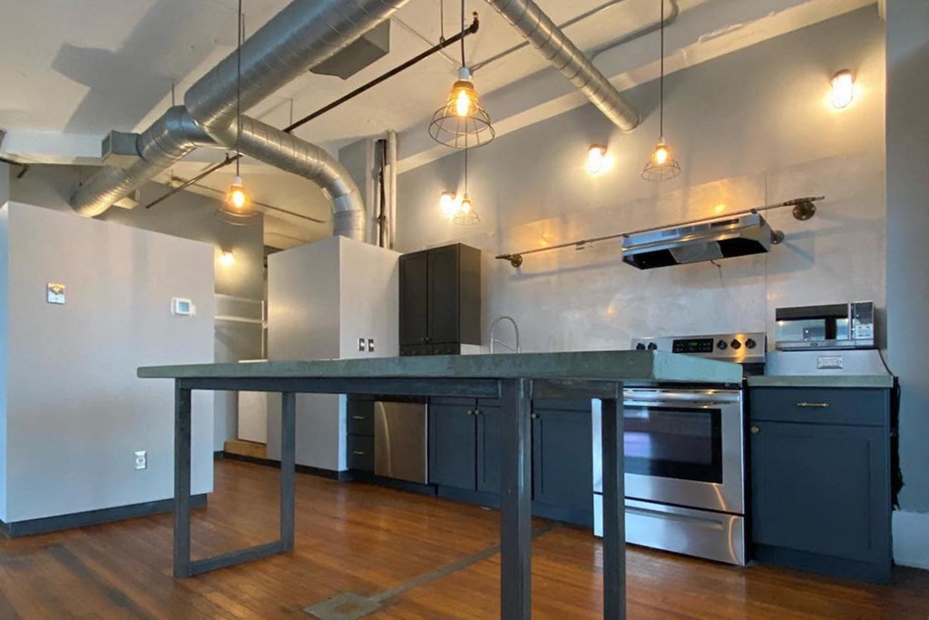 upgraded kitchen with pendant lighting, stainless steel appliances, and concrete island at Jemison Flats, Birmingham, Alabama
