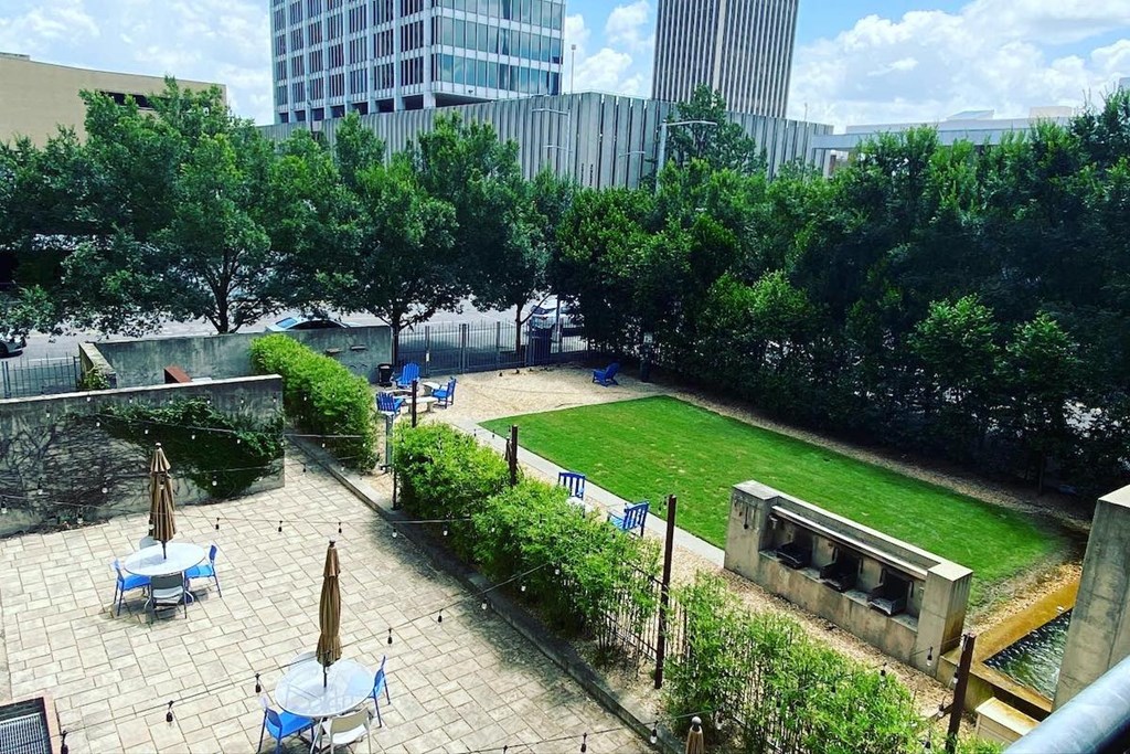 Large private park with picnic tables, green space, water feature, and firepit at Jemison Flats, Birmingham, 35203