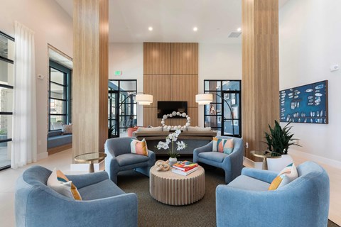 A modern living room with blue chairs and a coffee table.