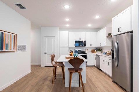 A modern kitchen with a dining table and chairs.