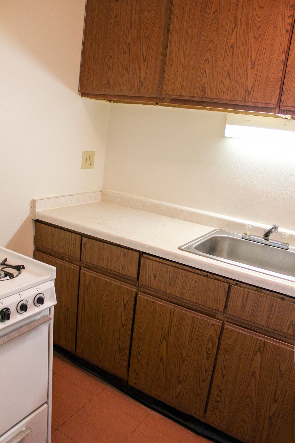 A white stove is in a kitchen with brown cabinets.