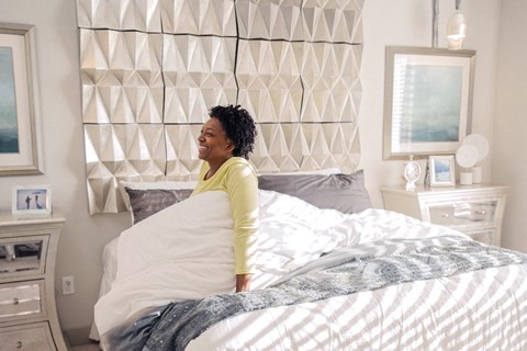 Woman waking up in comfortable bed at spacious LandonHouse