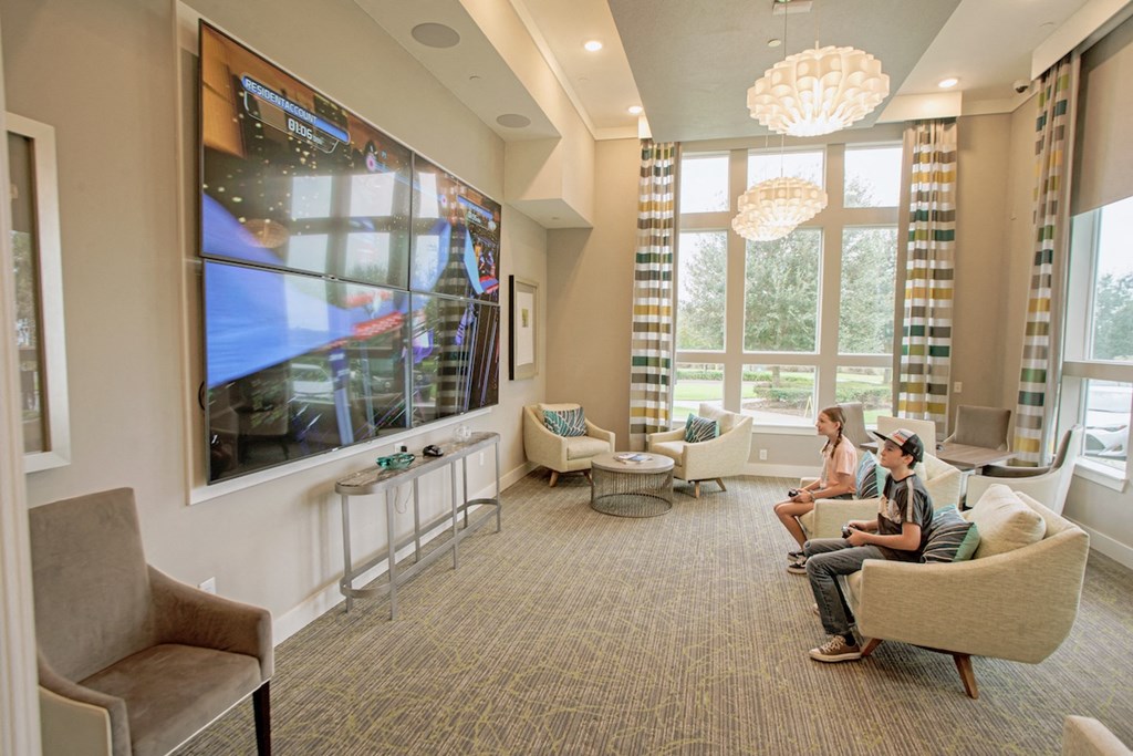 two kids playing video games on the massive TV in the media room