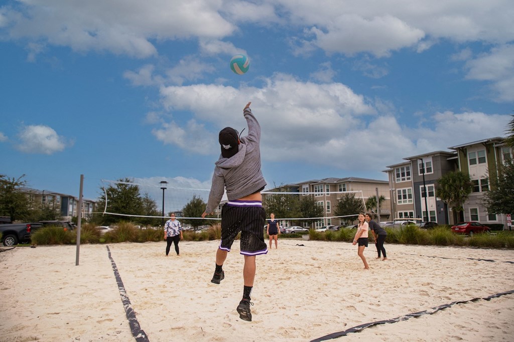 residents playing volleyball on sand court at Ariel