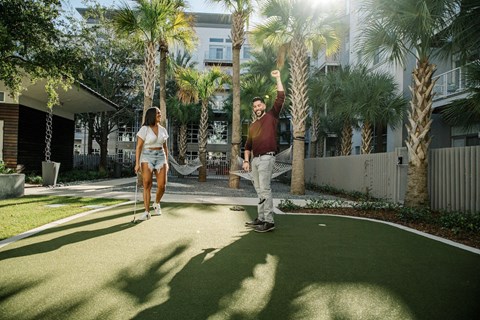 Two people enjoying the putting green at LandonHouse Apartments