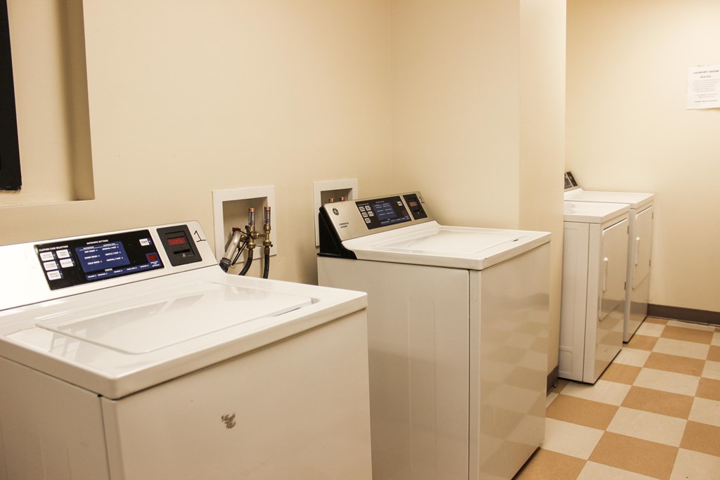 A row of white washing machines in a laundromat.