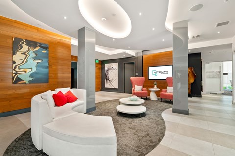 A modern living room with a white sofa and a large abstract painting on the wall.