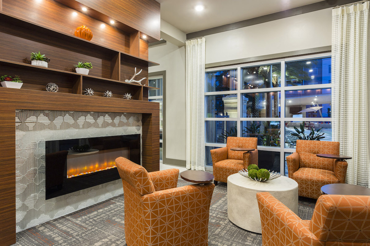 Fireplace and seating by pool window in resident lounge  at LandonHouse in Lake Nona
