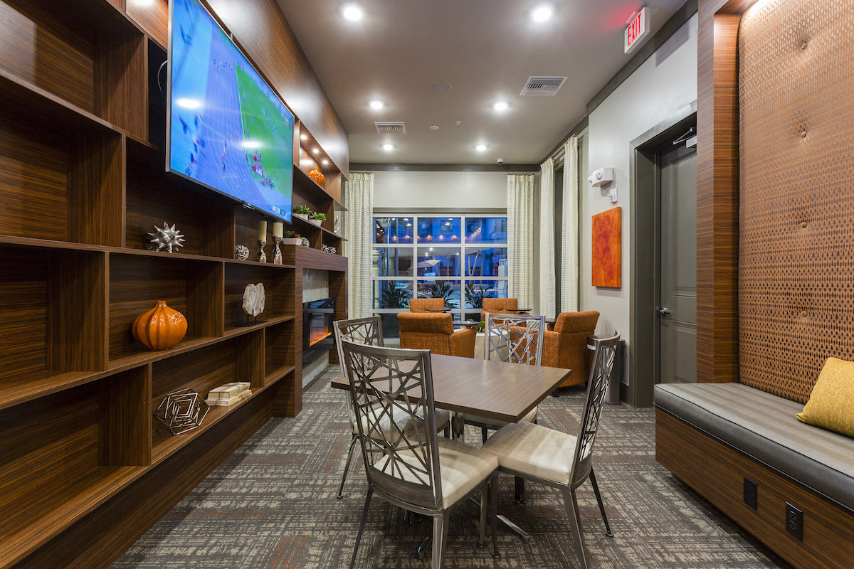 Lounge with tables chairs and tv  at LandonHouse in Lake Nona