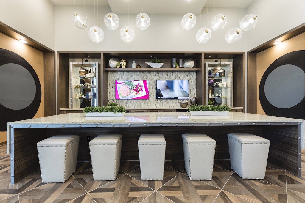 Lounge with tvs and bar top with padded stools at Residences at The Green in Lakewood Ranch, FL