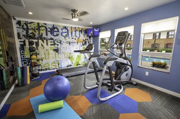 colorful fitness center with cardio and weight training equipment at The Mills at 601, Alabama - Photo Gallery 26
