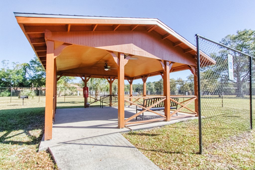 Outdoor pavilion with benches and a BBQ grill