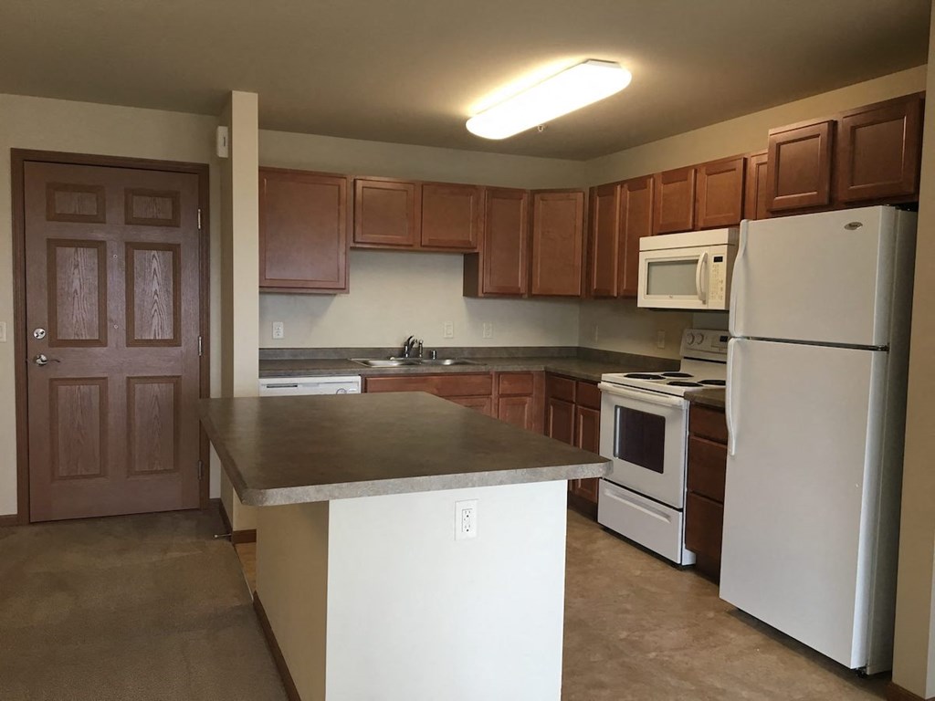 a kitchen with a white refrigerator freezer next to a stove top oven