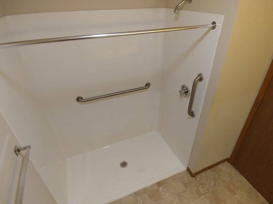 a bathtub with a grab bar in a hotel room