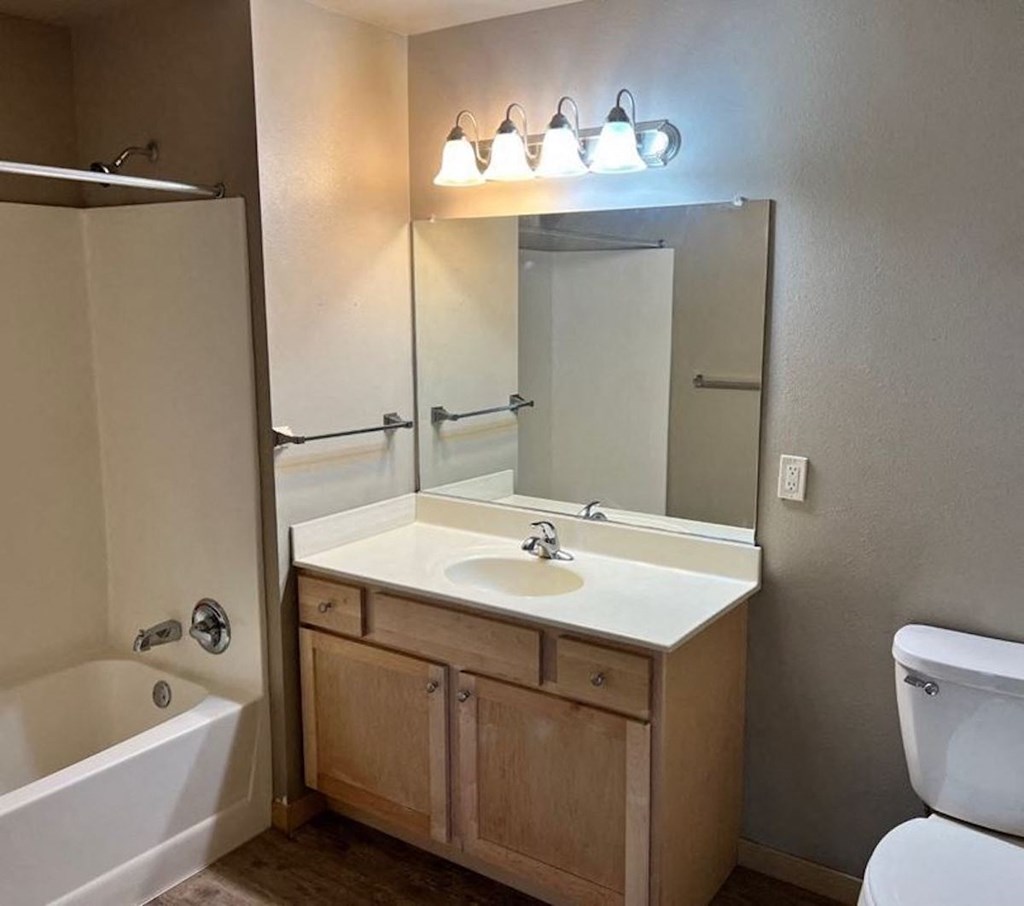 a bathroom with a sink toilet and bathtub at Pioneer Ridge Apartments