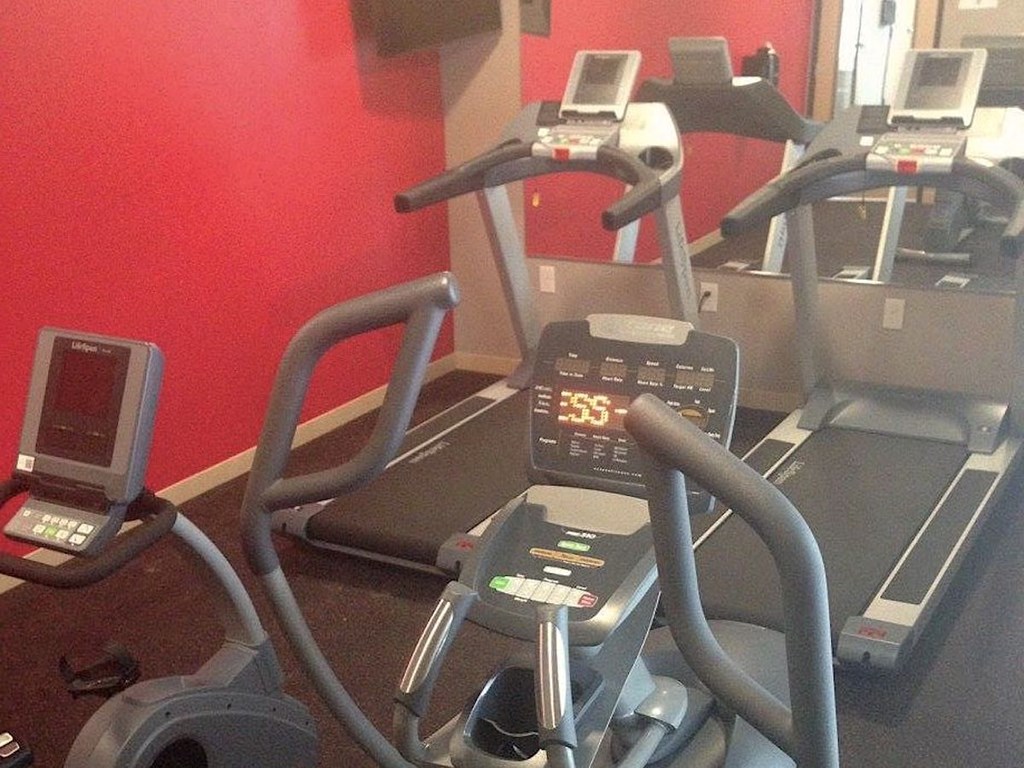 a treadmill and elliptical machines in the fitness center at Pioneer Ridge Apartments