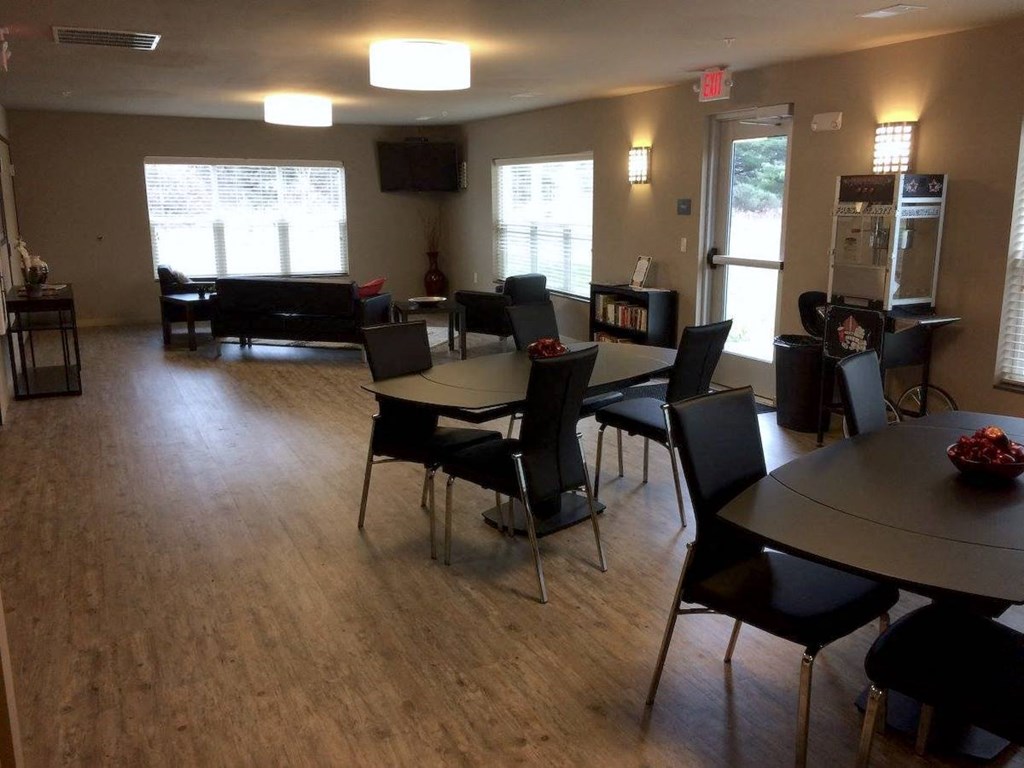 community clubhouse room with tables, chairs, couches, and a popcorn machine at Pioneer Ridge