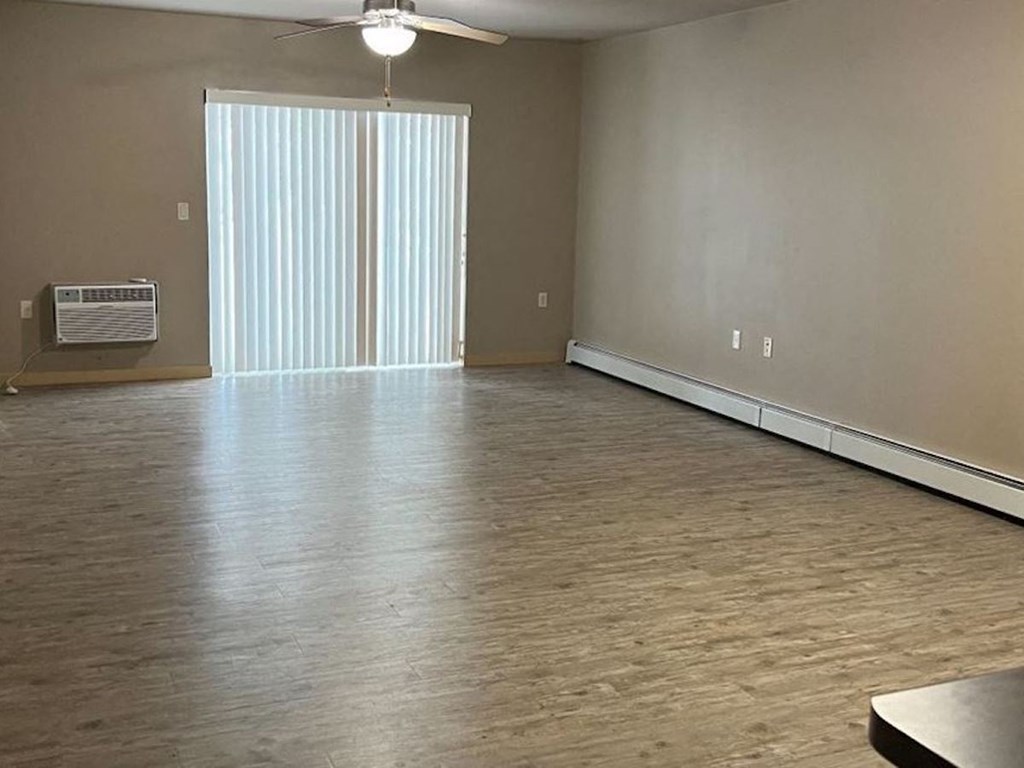 spacious living room with hardwood LVP, sliding glass doors, and a ceiling fan
