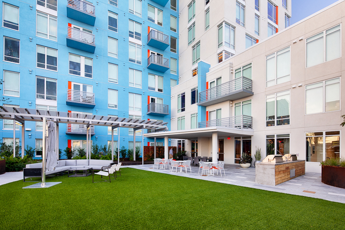 Apartments overlooking outdoor kitchen and lounge on amenity deck at Lake Nona Pixon, Orlando, 32827