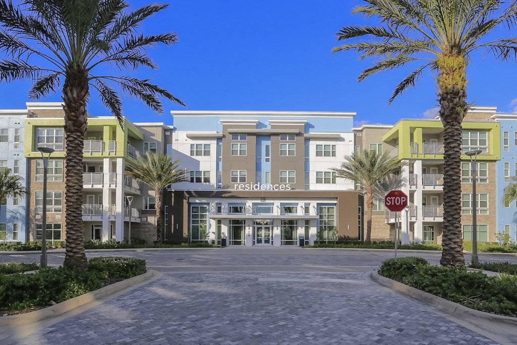 Exterior of Residences at The Green clubhouse with towering palms