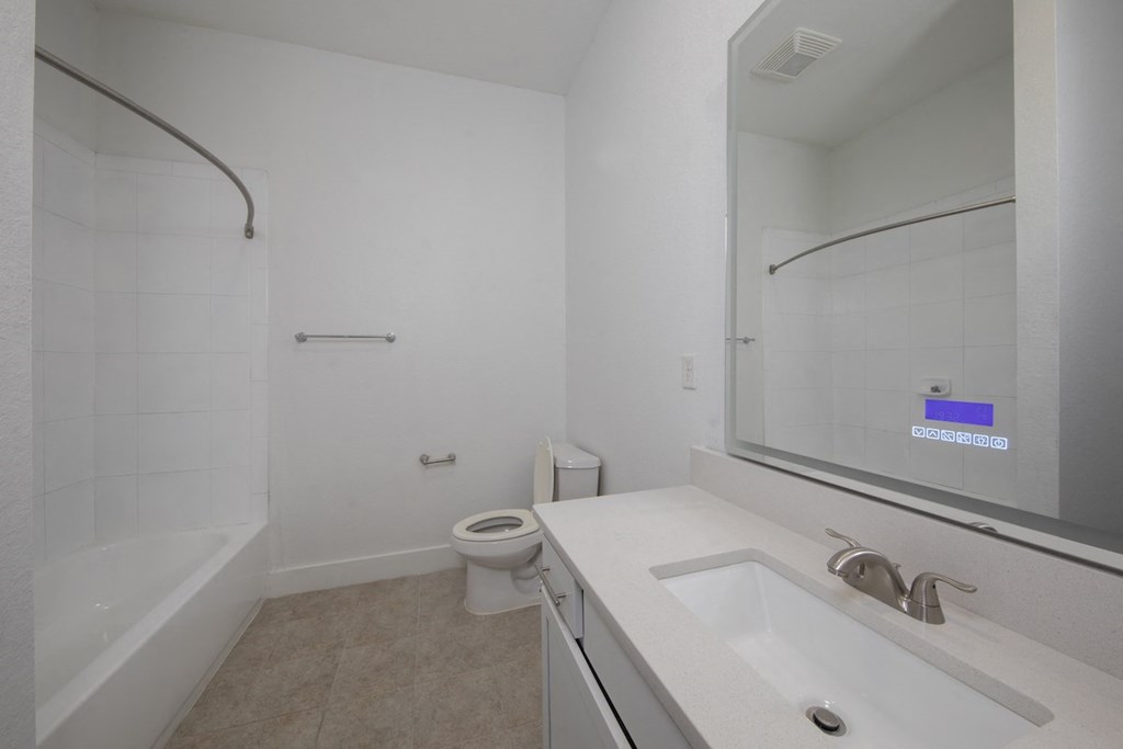 Spacious bathroom with smart mirror, tub, shower, toilet, and sink vanity at Rise Lakeview at Rise Lakeview Apartments in Birmingham, AL