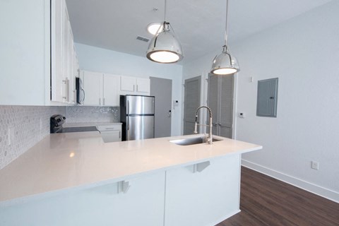 Kitchen with granite countertops, modern fixtures, and white cabinets at Rise Lakeview Apartments in Birmingham, AL